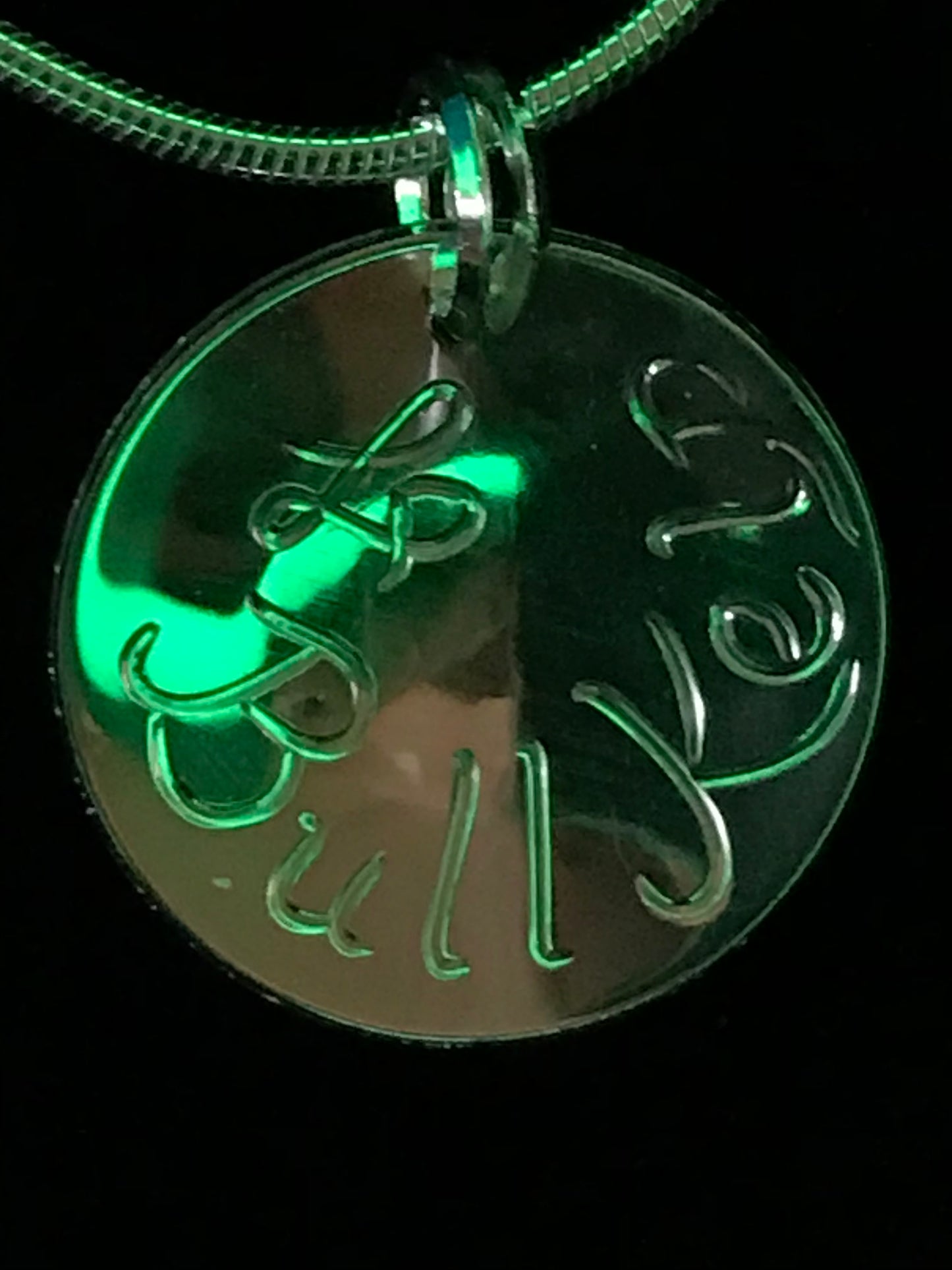 Photographed in a green light to give the effects of the ocean kelp , this is the back of pendant engraved with artist's initials and Bull Kelp.
