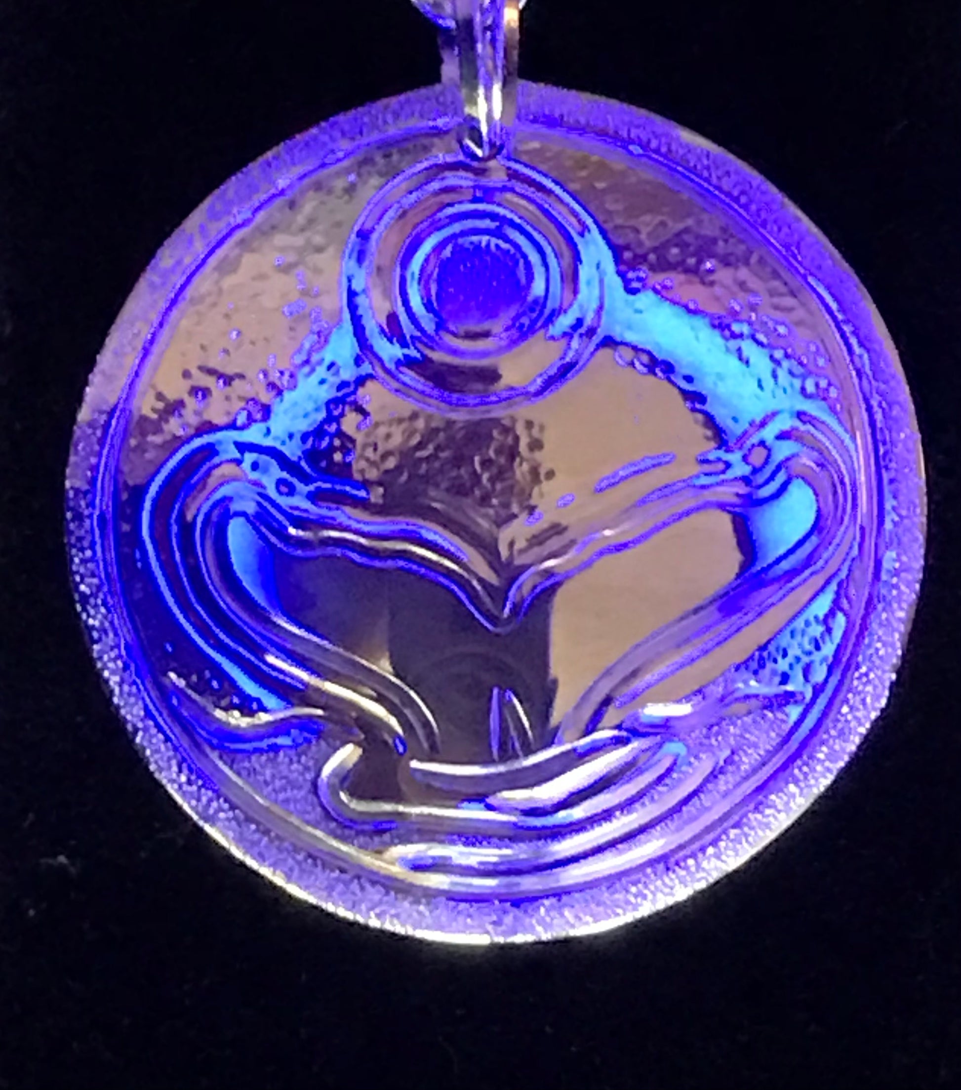 Photographed in a blue light to give the effects of ocean shimmer on the Whale Tail and Full Moon sterling silver pendant by Laura Dutheil.