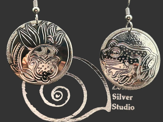 Lady slipper and tree frog sterling silver 1 inch round earrings by Laura Dutheil. Two images of protected species of Haida Gwaii forest.