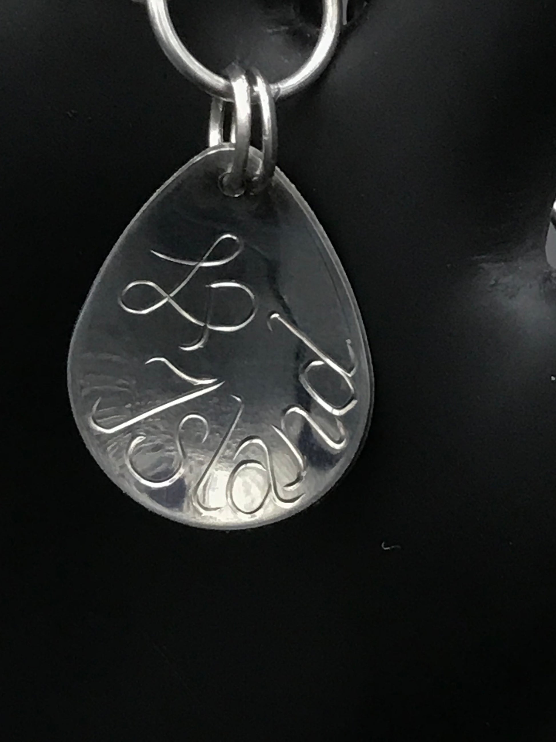 Back of charm with artist initial and Island engraved