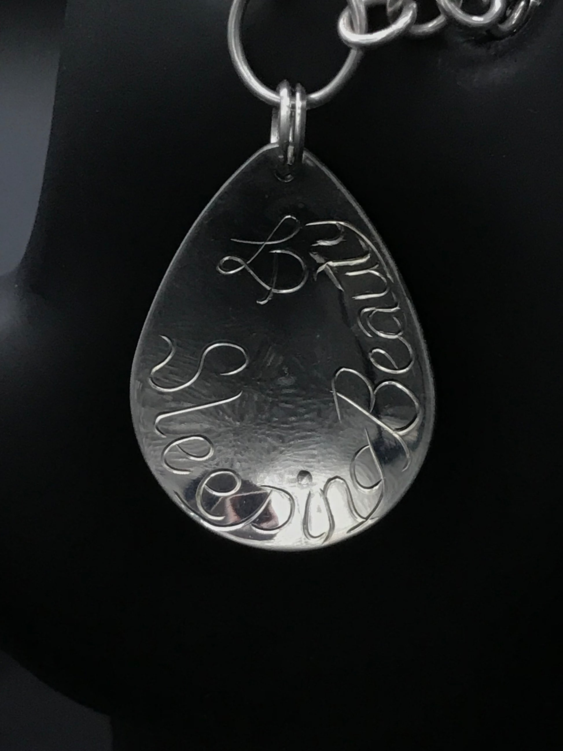 artist initials and sleeping beauty words engraved on back on charm