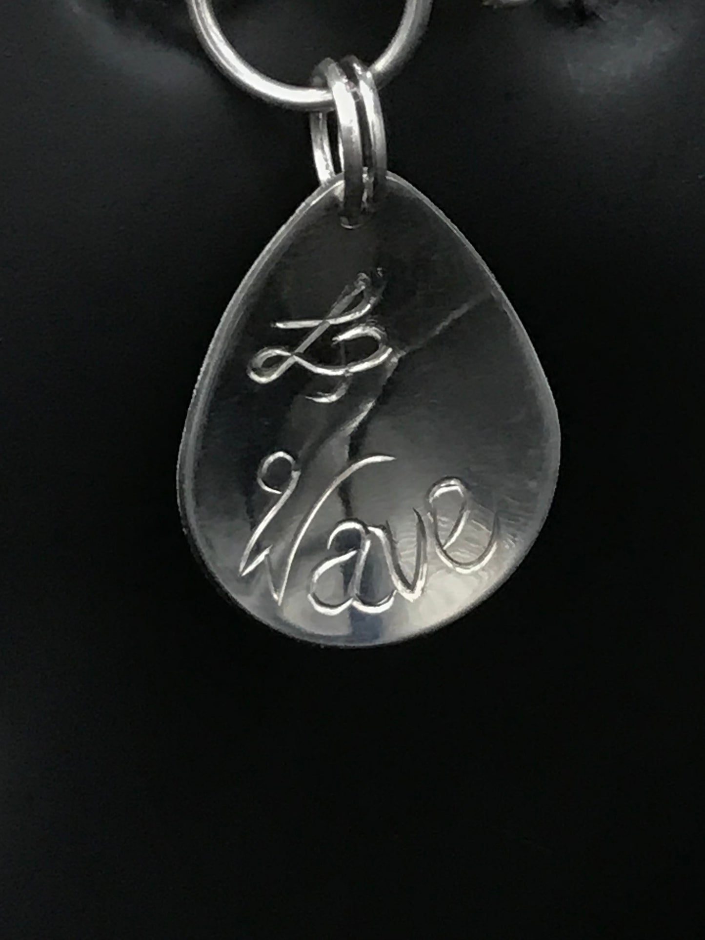artist initial and Wave engraved on back of charm 